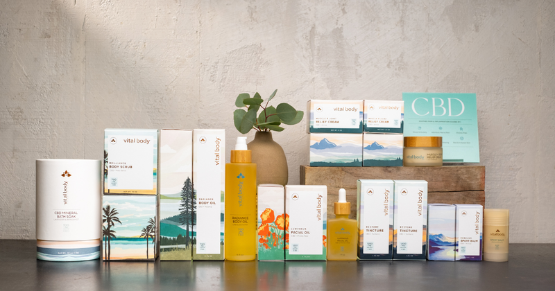 Vital Body Therapeutic's CBD product line on a counter: mineral bath soak, body scrub, body and facial oils, muscle and joint relief cream, tinctures and sport balm