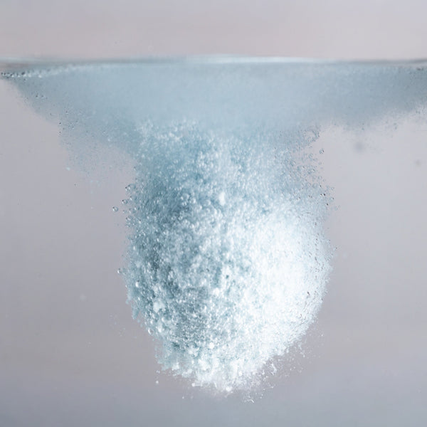 Close-up of a fizzy bath bomb dropped in water
